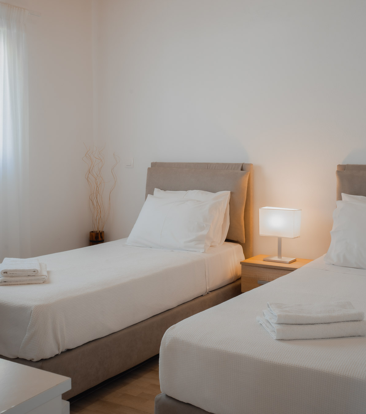 Twin beds with warm bedside lighting