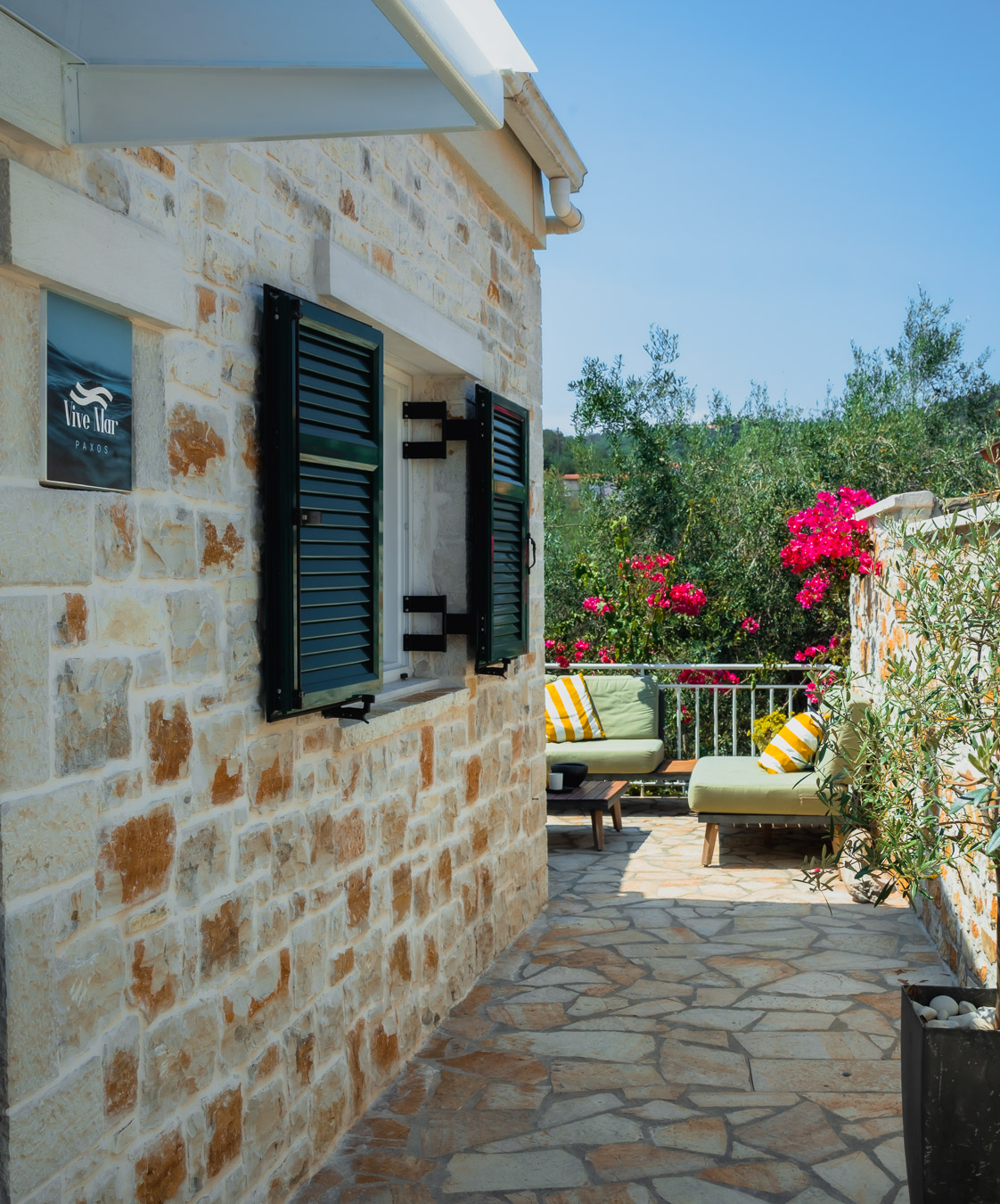 Stone terrace path with Vive Mar Paxos sign