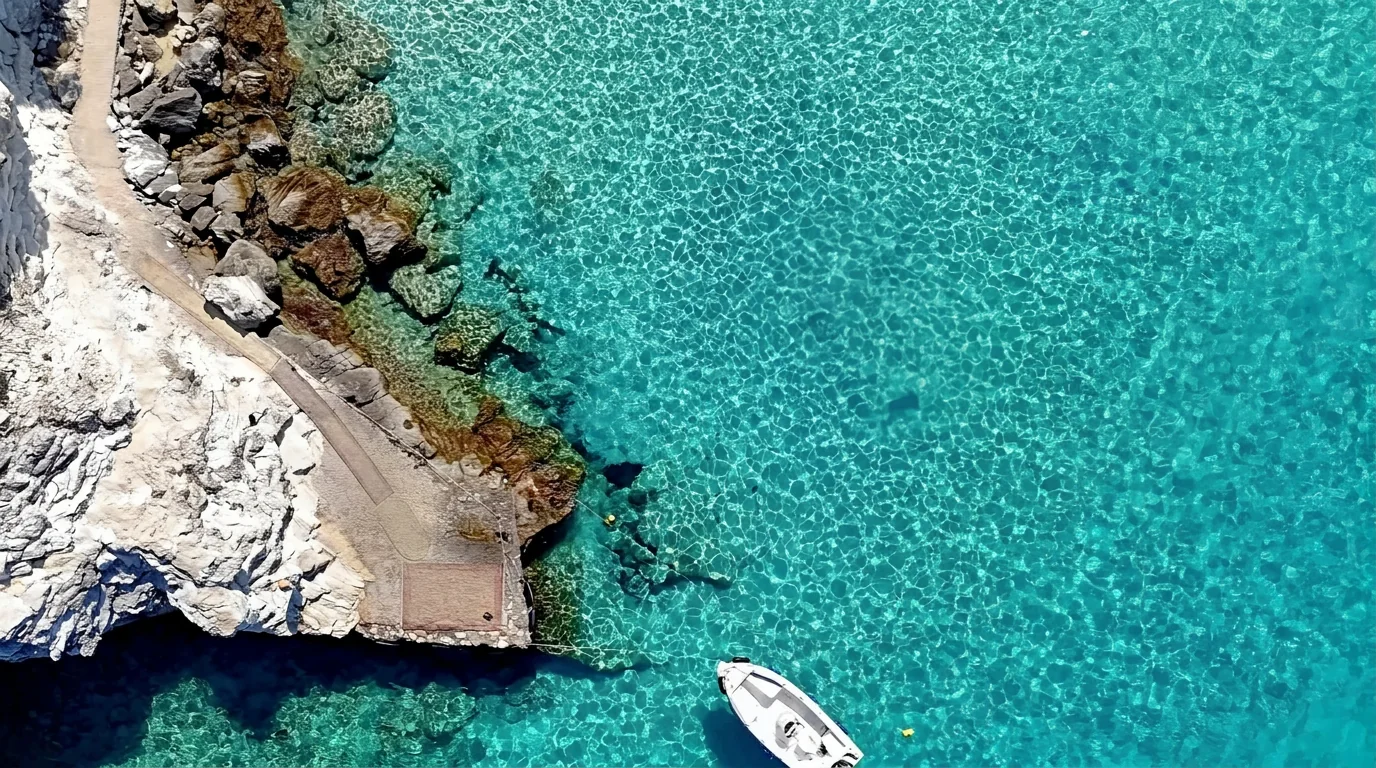 Aerial view of the turquoise Ionian Sea beside the rocky Paxos coastline